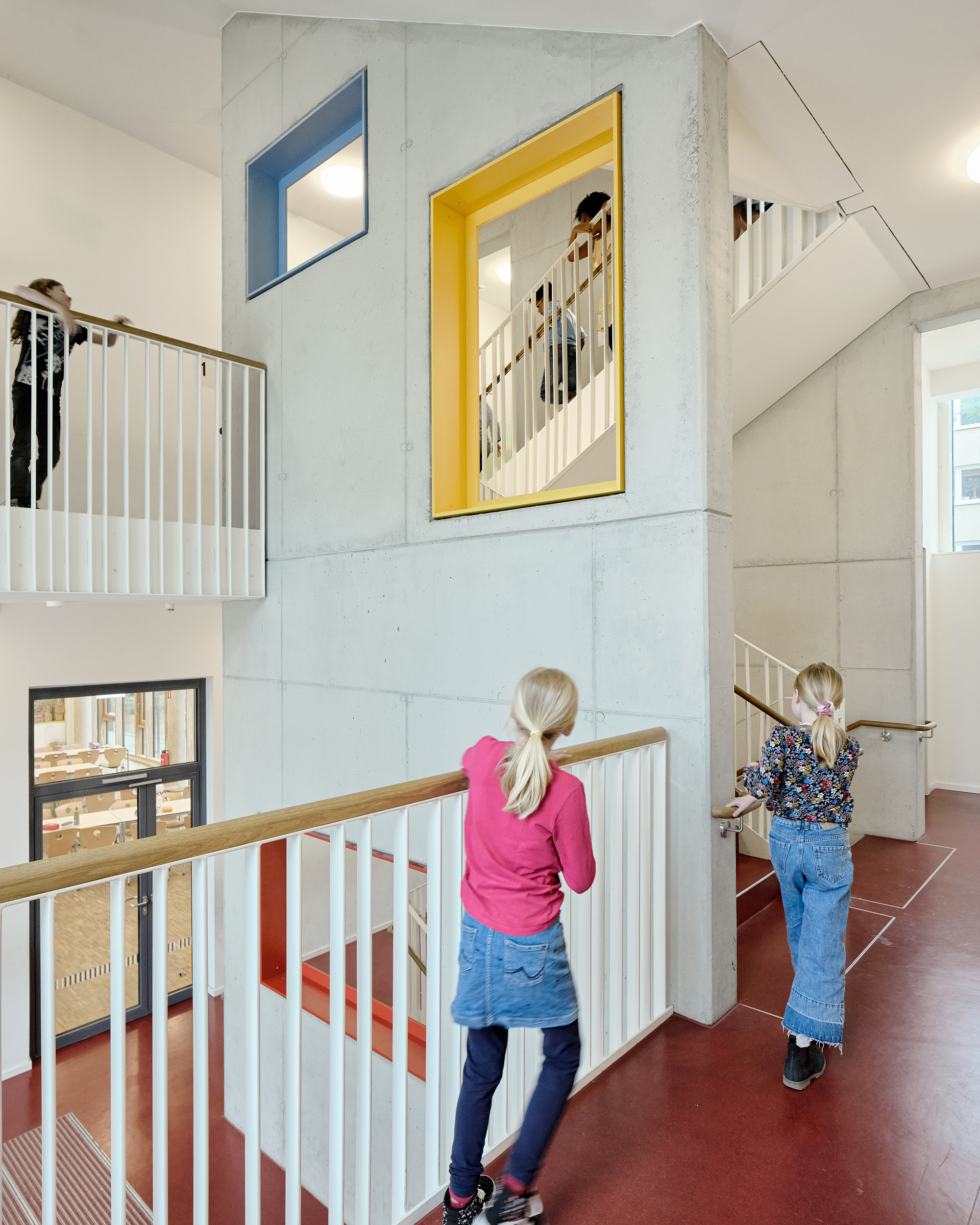 Kinder in einem bunten Treppenhaus und auf Galerien